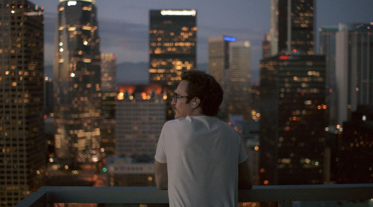Joaquin Phoenix looks across the cityscape