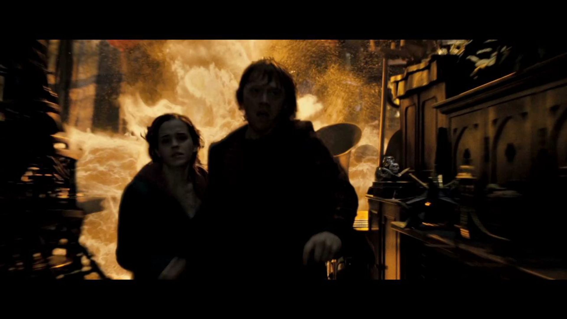 Harry, Hermione and Ron run from the fire in the Room of Requirement